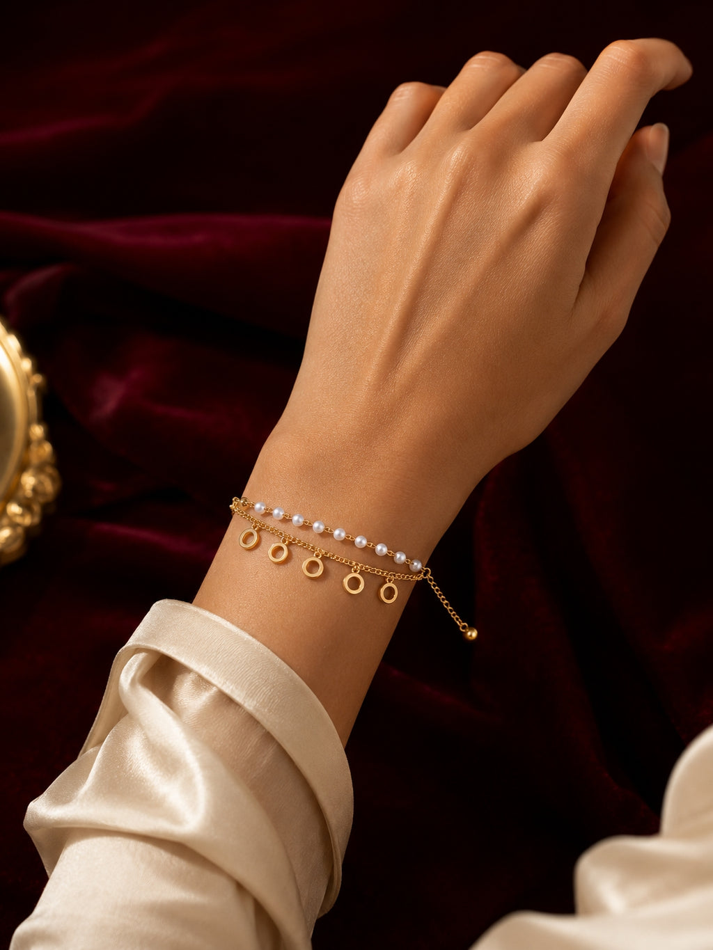 Adjustable pearl bracelet with circle charms worn on wrist with satin sleeve