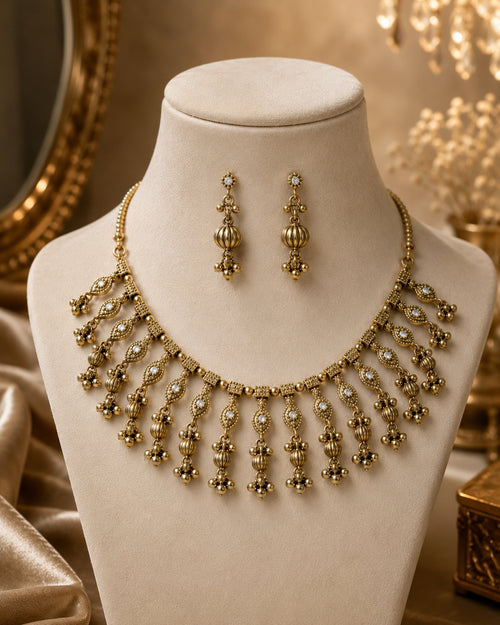 Antique gold necklace set with earrings on golden fabric