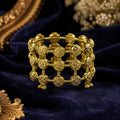 Gold antique coin lattice bangle on white marble surface