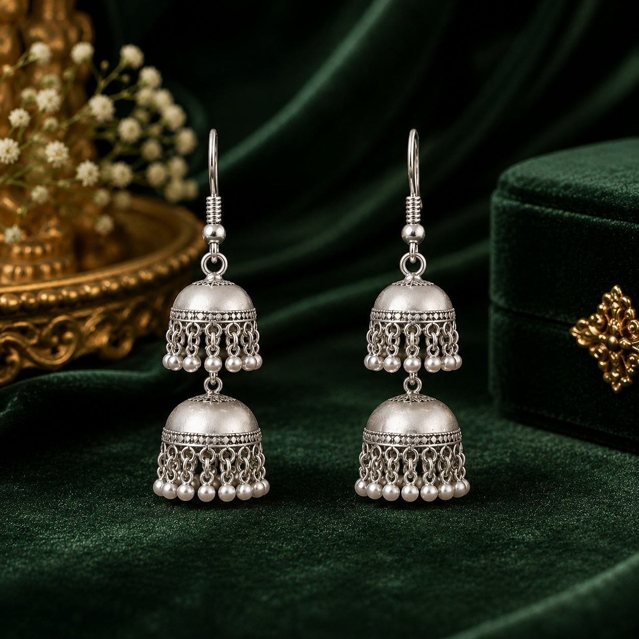 Oxidised silver double jhumka earrings with pearl drops on green velvet