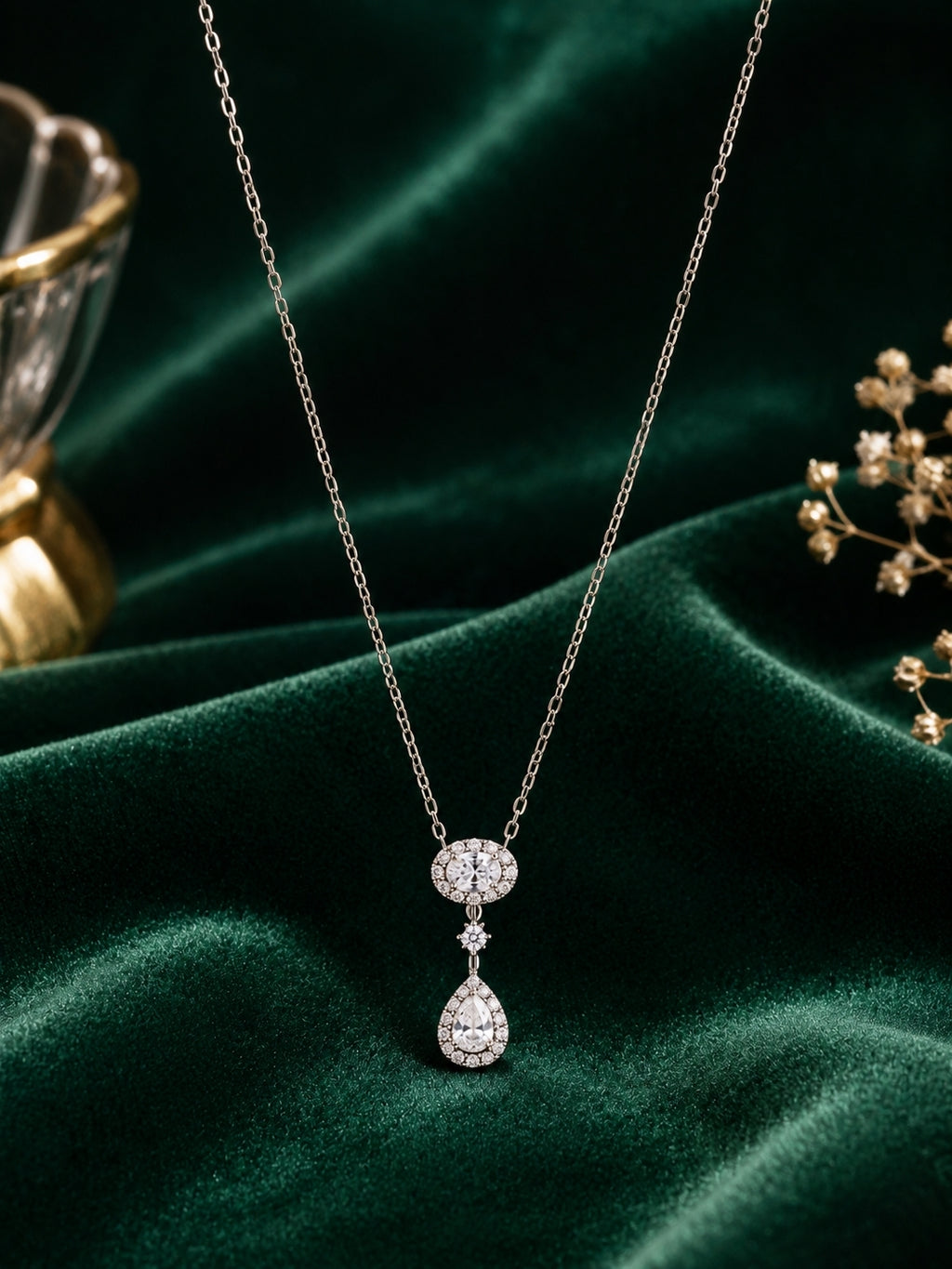 Elegant silver CZ pendant necklace on dark green velvet background