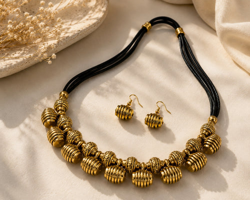 Antique brass bead necklace set worn by model - front view