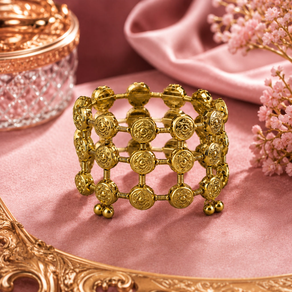 Model wearing gold coin lattice bangle with cream saree
