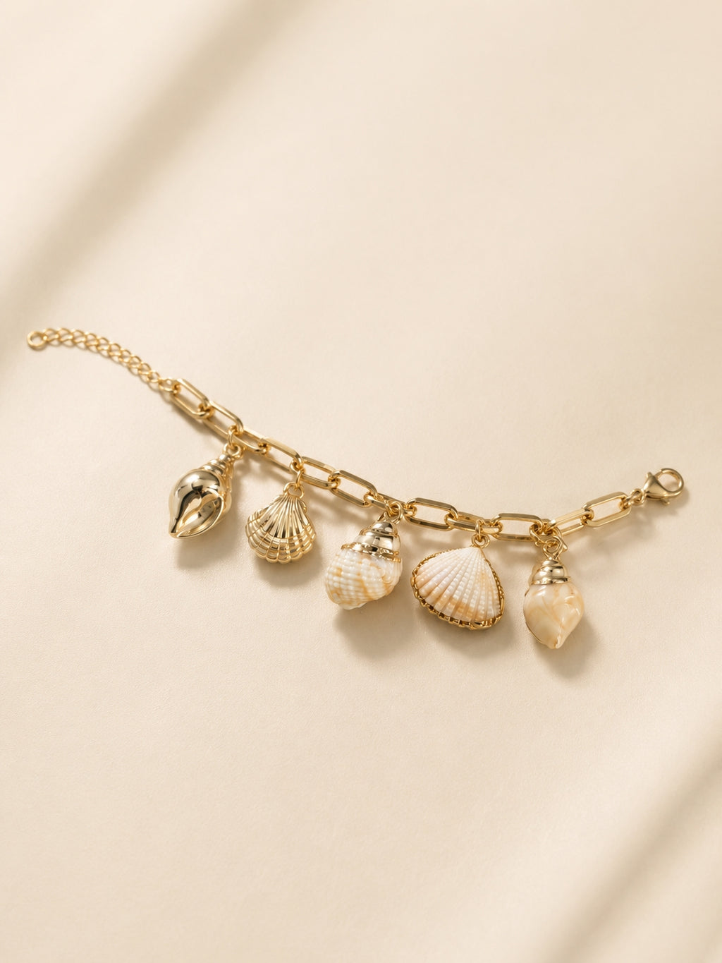 Gold-toned seashell charm bracelet detail shot showing all 5 shell charms