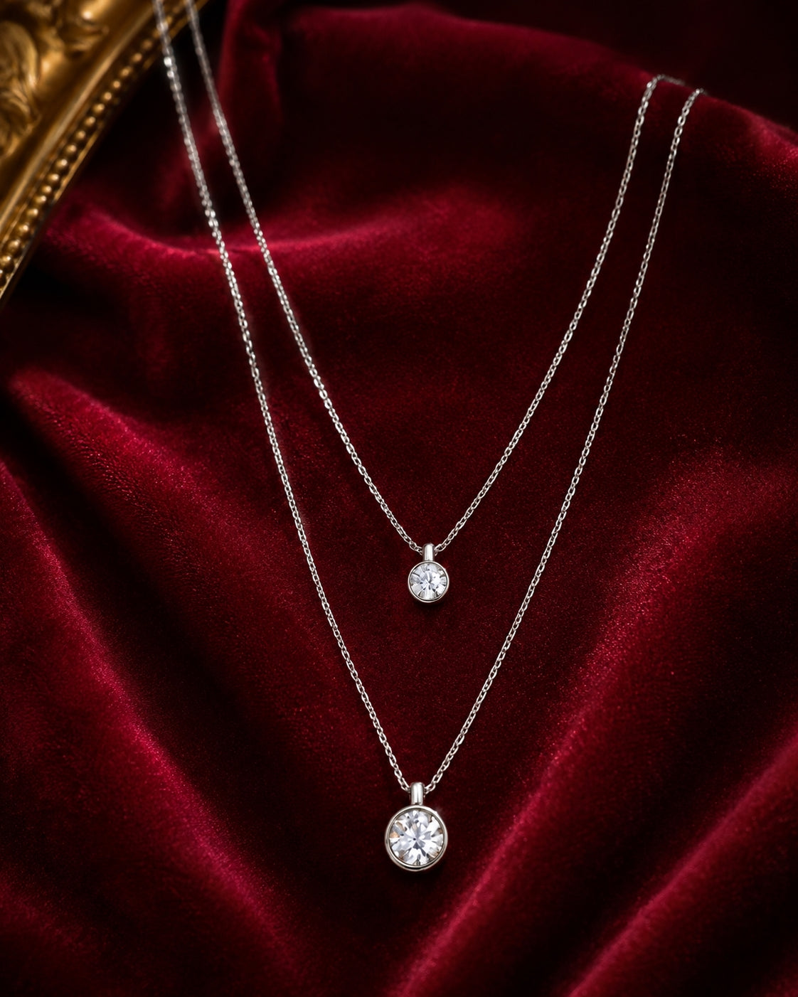 Silver double layer CZ bezel necklace flat lay on red velvet background