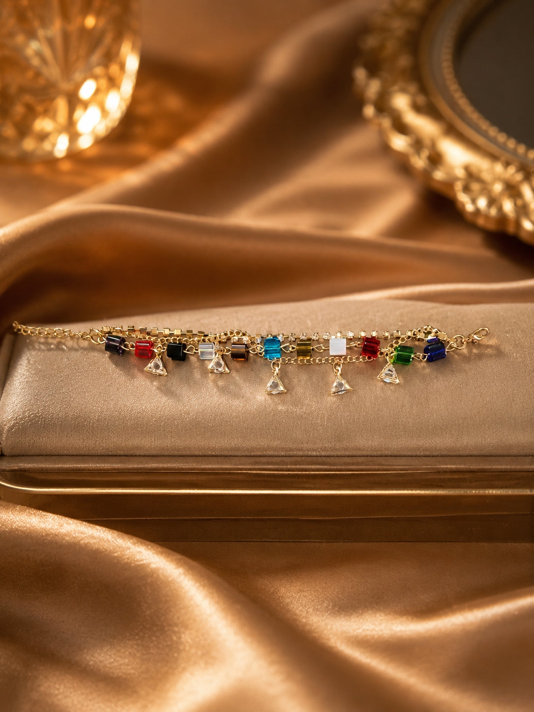 Gold-toned multicolour crystal cube bracelet with triangle CZ charms on gold satin jewellery box