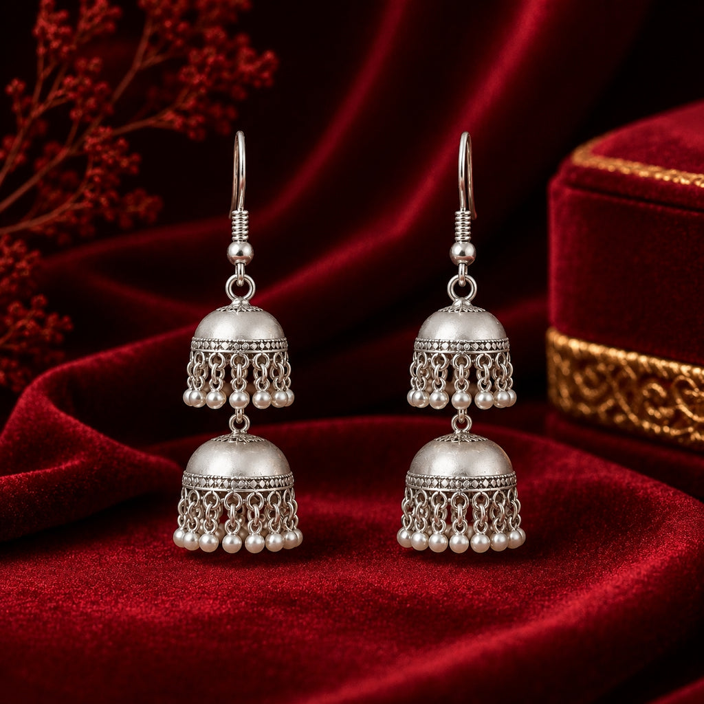 Oxidised silver double jhumka earrings with pearl drops on red velvet