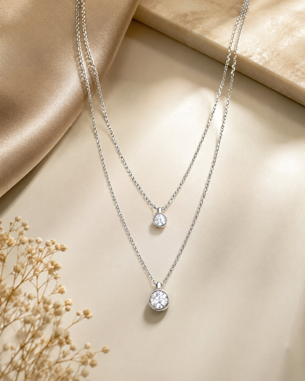 Silver double layer CZ pendant necklace on beige satin with dried flowers