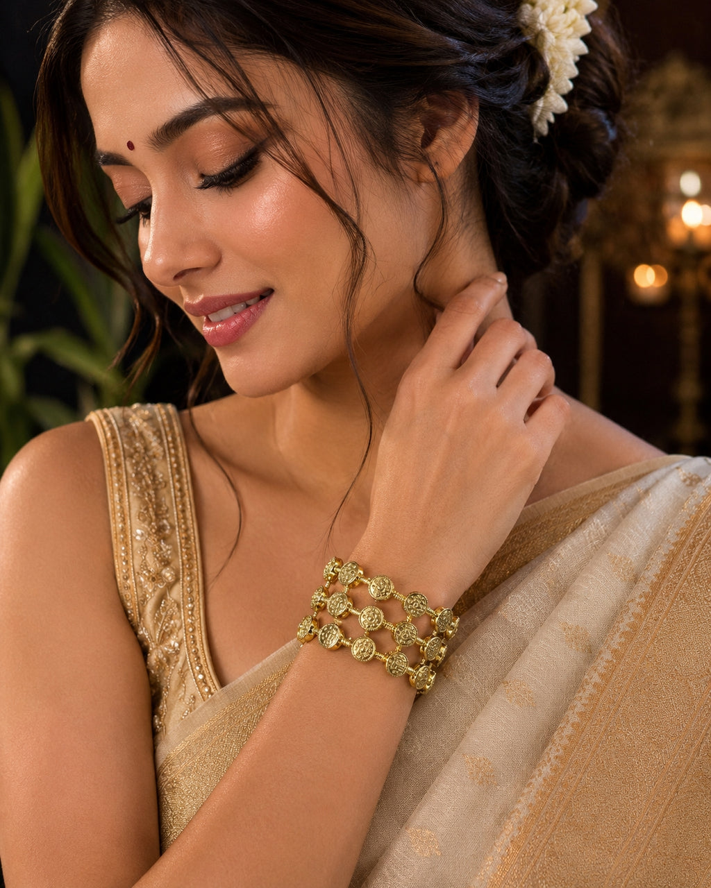 Model wearing gold coin lattice bangle with maroon and cream saree