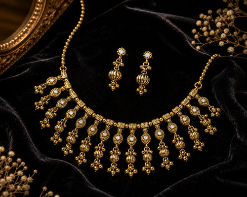 Antique gold necklace set with earrings on mannequin bust
