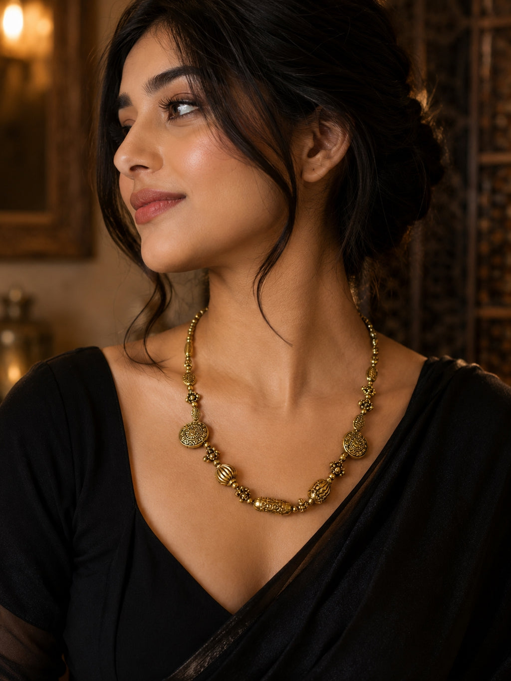 Woman wearing antique gold beaded necklace with matching earrings
