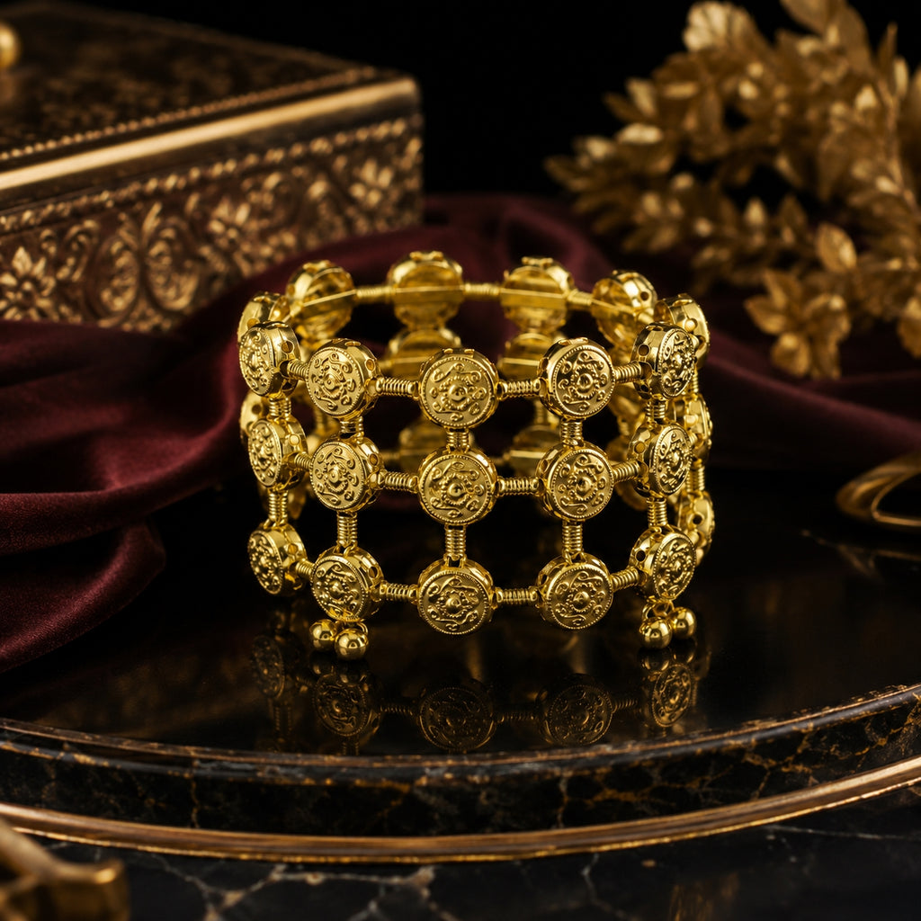 Gold coin lattice bangle on navy blue velvet background